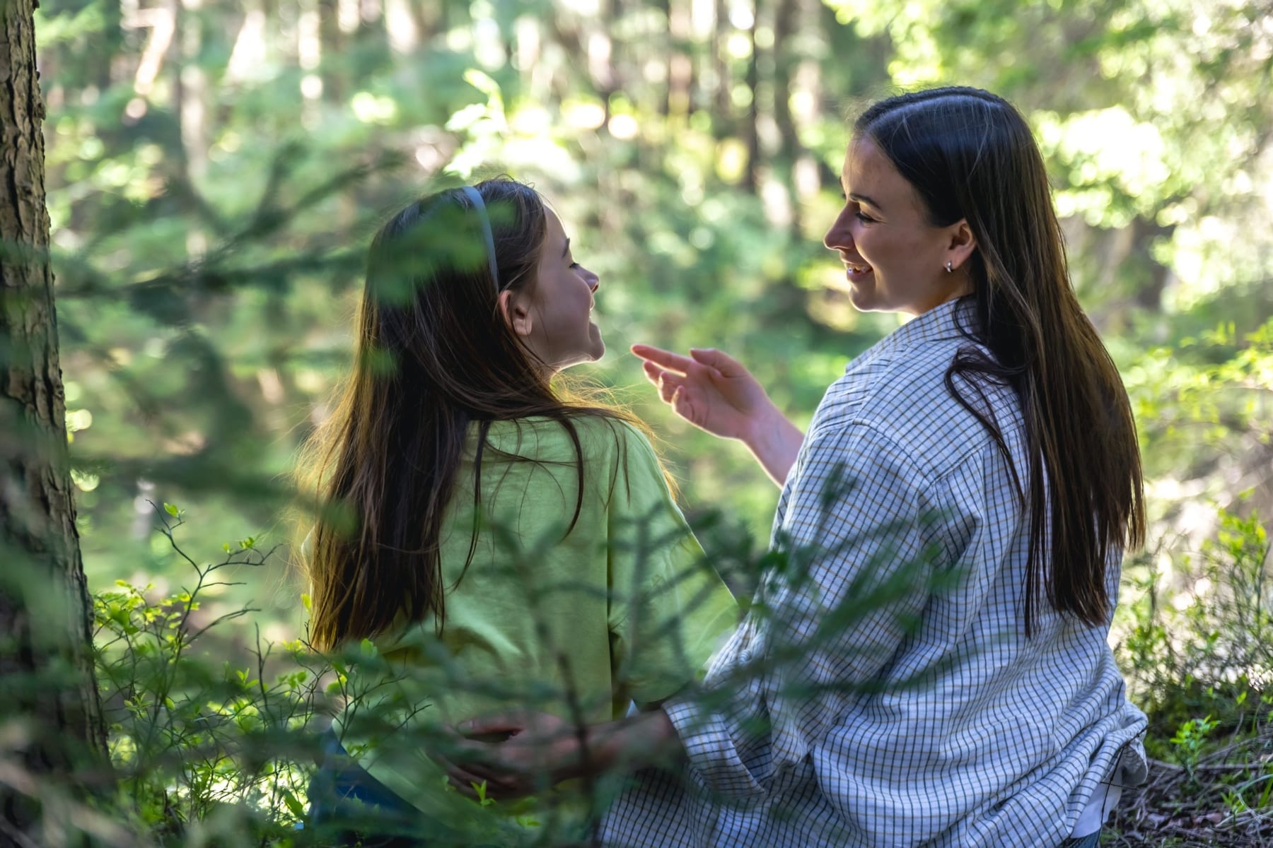 Una madre y su hija conversan juntas en el bosque