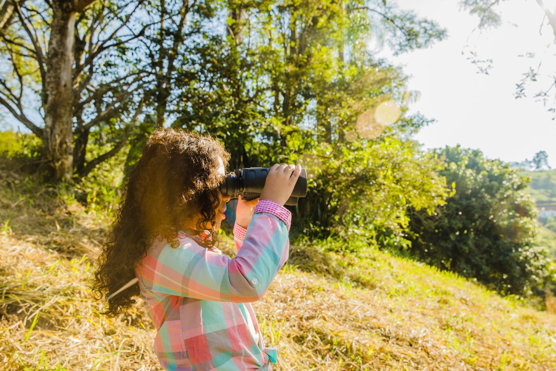 Una niña observa el territorio con prismáticos