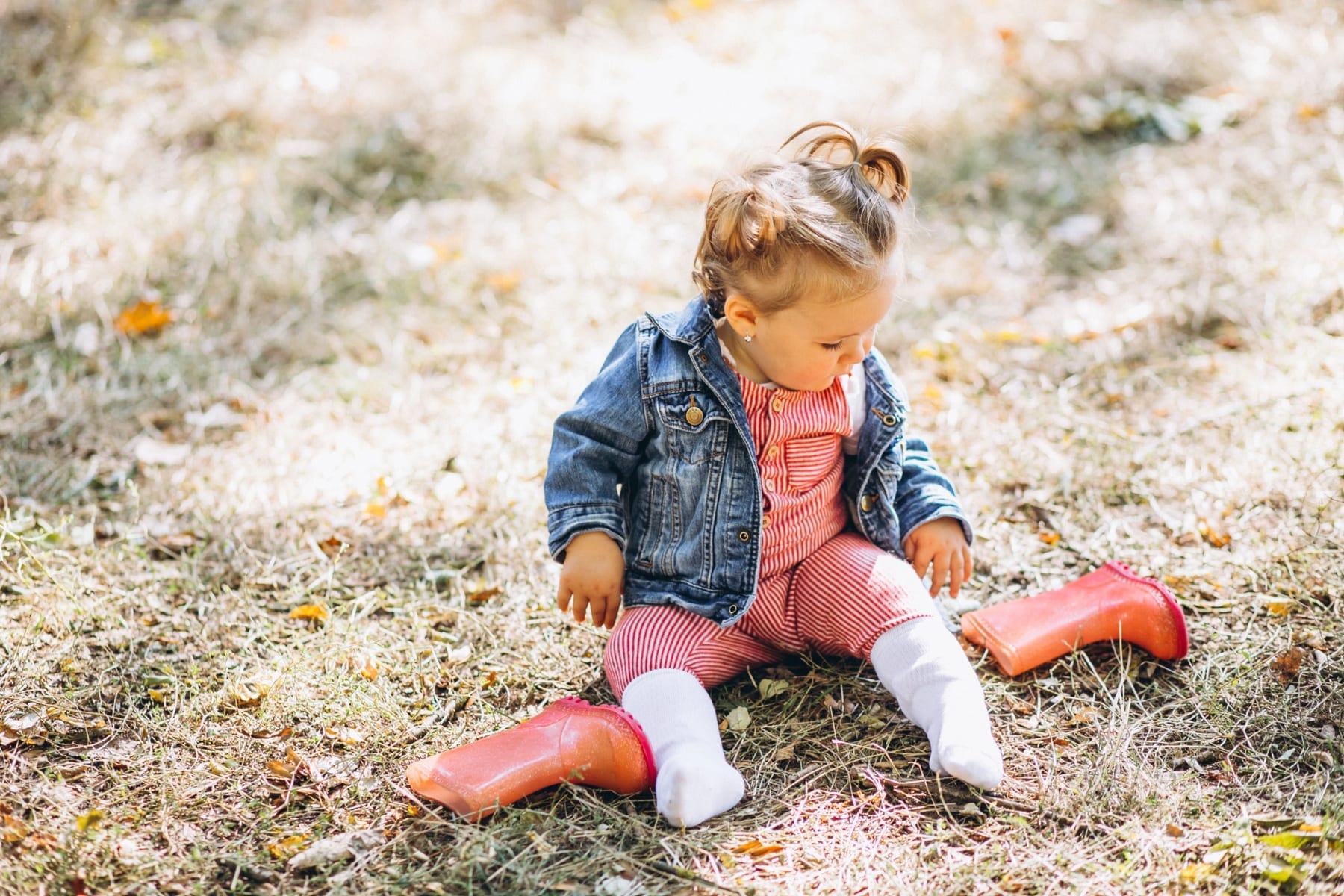 Una niña pequeña explora el entorno con sus botas