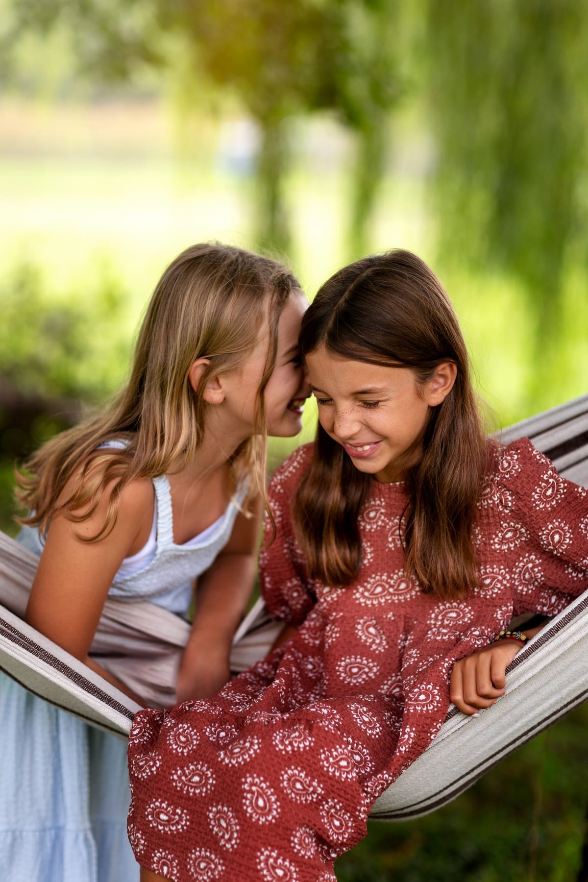 Dos niñas comparten un momento de lectura en una hamaca